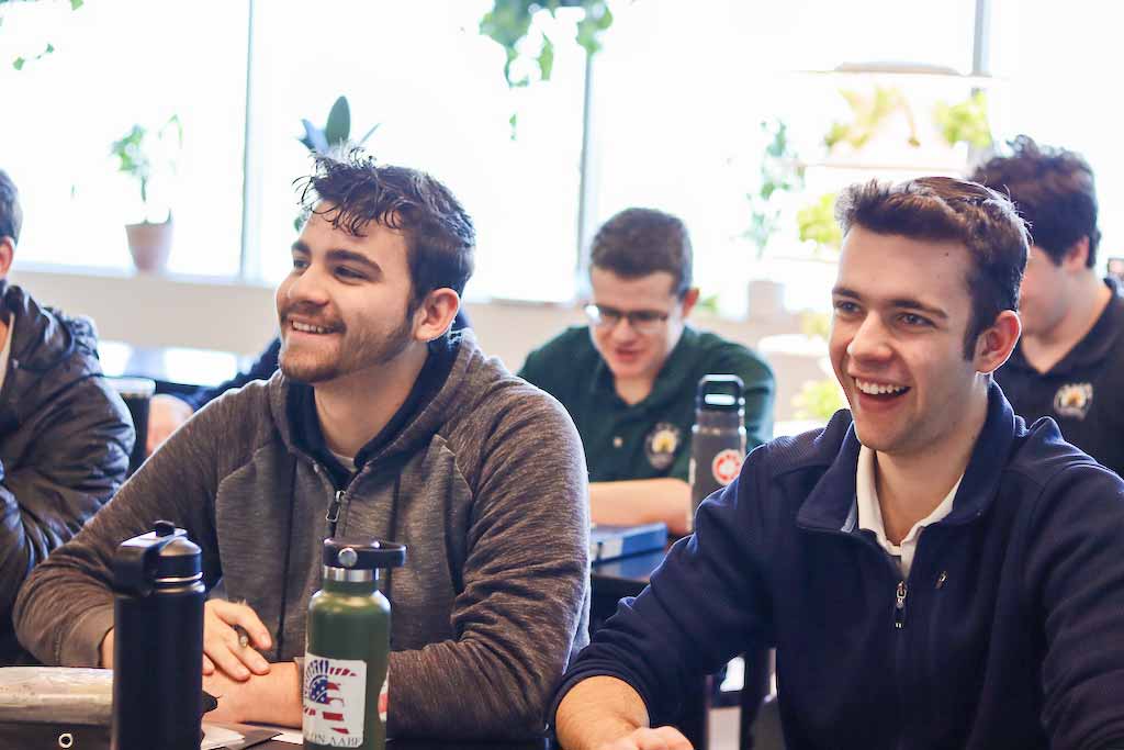 Three smiling boys working on an in class assignment