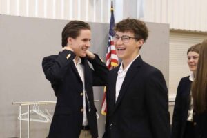 Two students in uniforms, laughing
